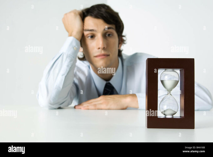 joven-mirando-el-reloj-de-arena-sosteniendo-la-cabeza-b4a16b.jpg