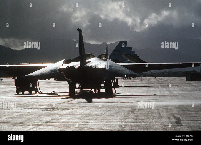 1975-a-right-rear-view-of-an-f-111-aircraft-half-silhouetted-by-sunlight-amid-dark-clouds-RA6294.jpg